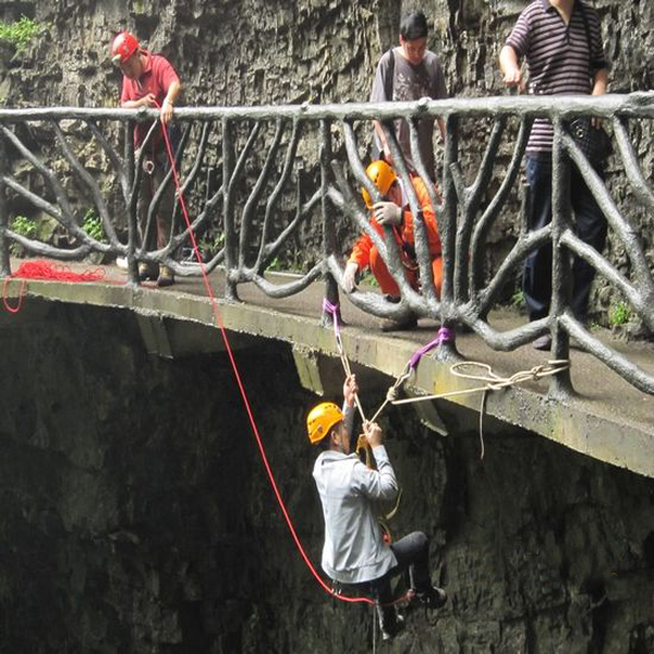Volunteers pick up the rubbish on cliff with their body tied in zhangjiajie park