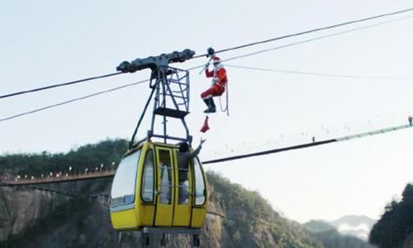 Santa Claus Hunging on the cable to send gifts to the tourists in Zhangjiajie 