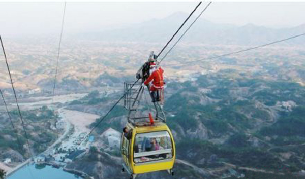 Santa Claus Hunging on the cable to send gifts to the tourists in Zhangjiajie 